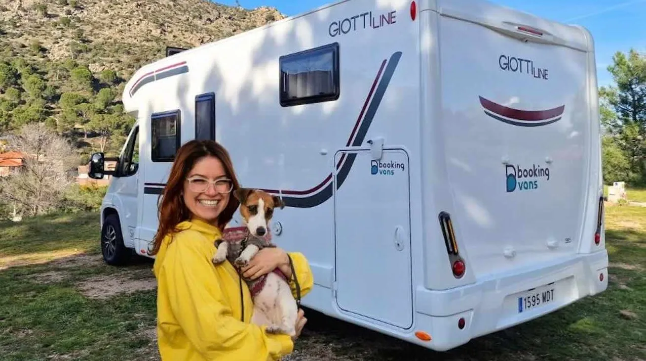 Perro asomado a una autocaravana durante una escapada