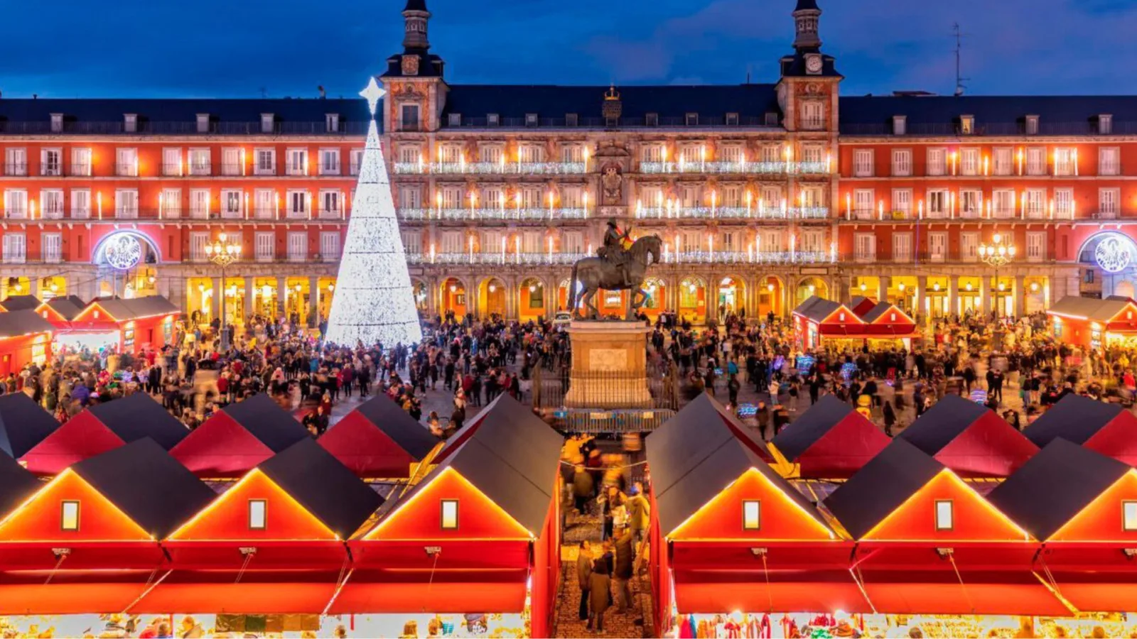 Autocaravana frente a un mercado navideño iluminado en España