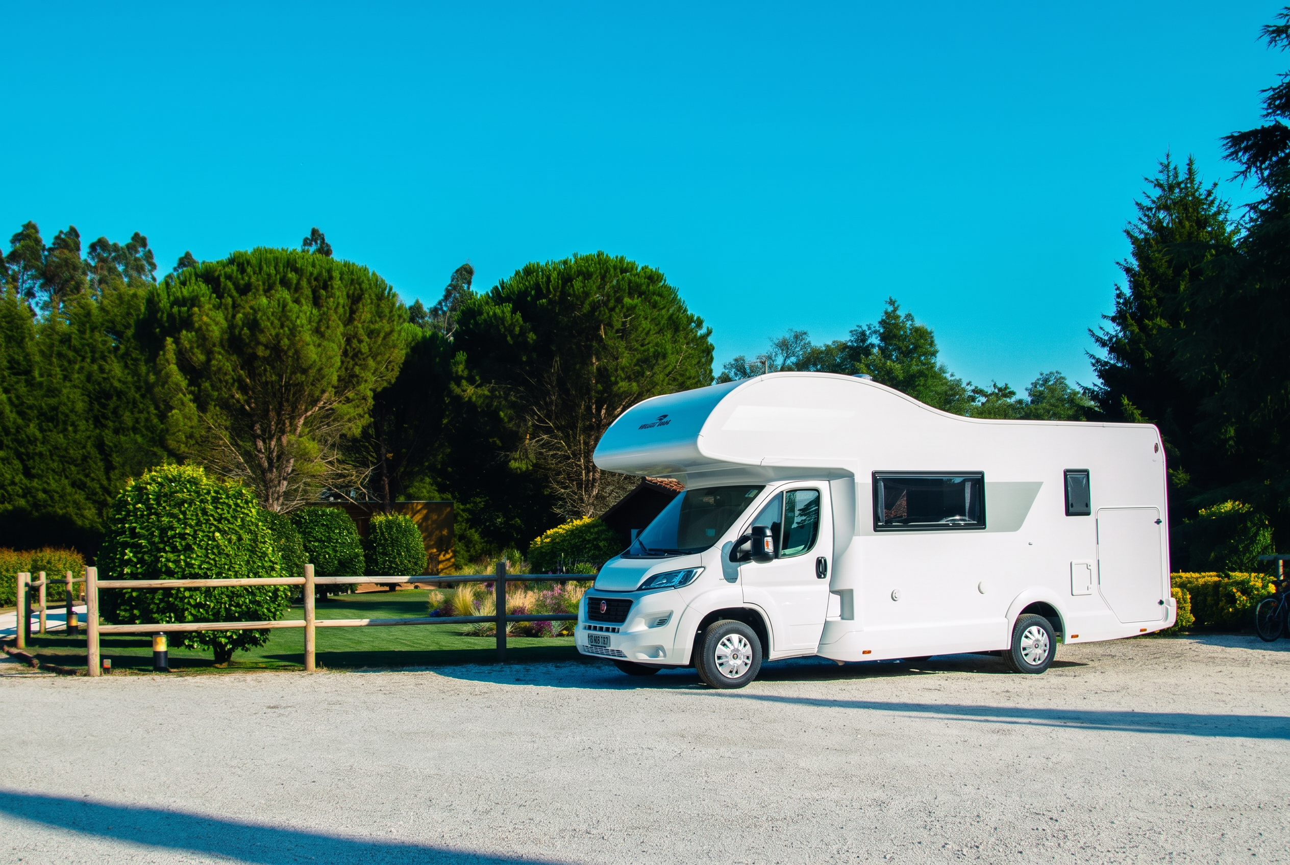 Autocaravana Roller Team Kronos 279 M de Bookingvans aparcada entre árboles