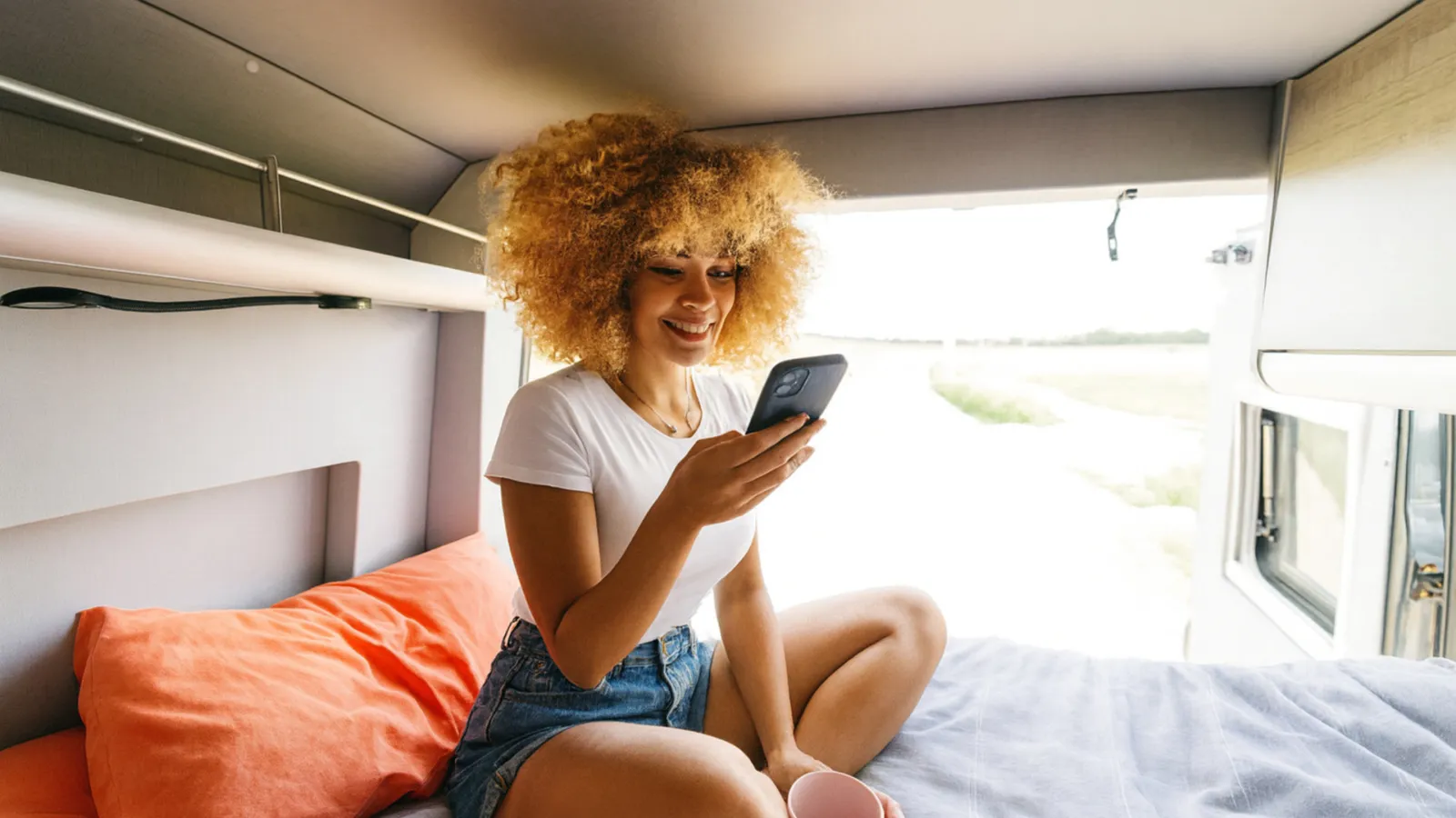 Móvil con una app de viaje dentro de una autocaravana