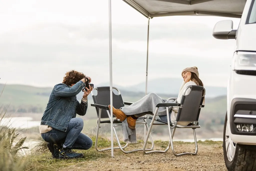 Pareja disfrutando de la naturaleza junto a su camper en San Valentín